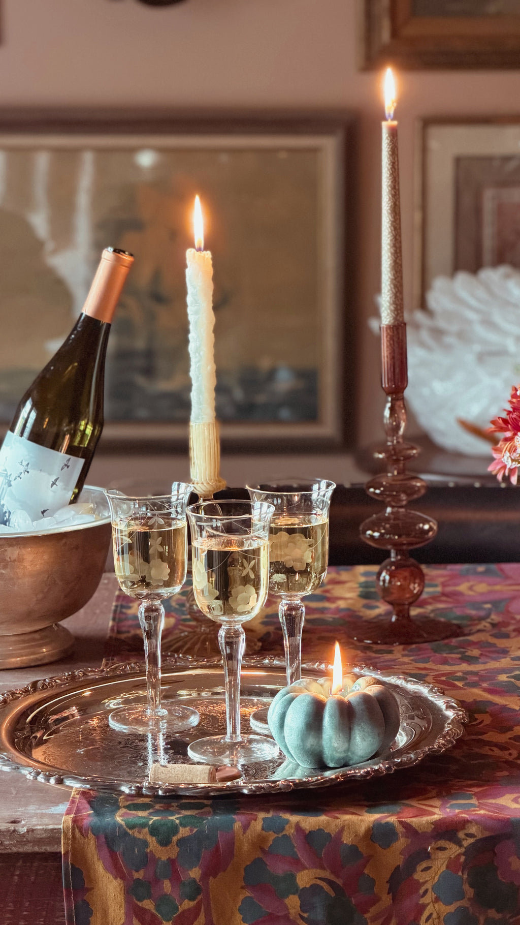 A table set with candles  and wine and a set of Vintage Etched Crystal Tulip Wine Glasses on a silver tray
