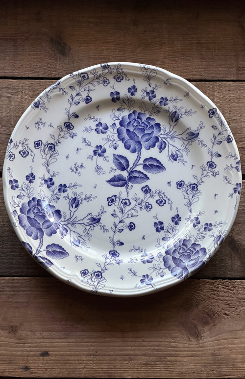 Vintage Quadrifoglio Italy Blue Chintz Floral Dinner Plate, photographed from directly above on a rustic dark wood background.