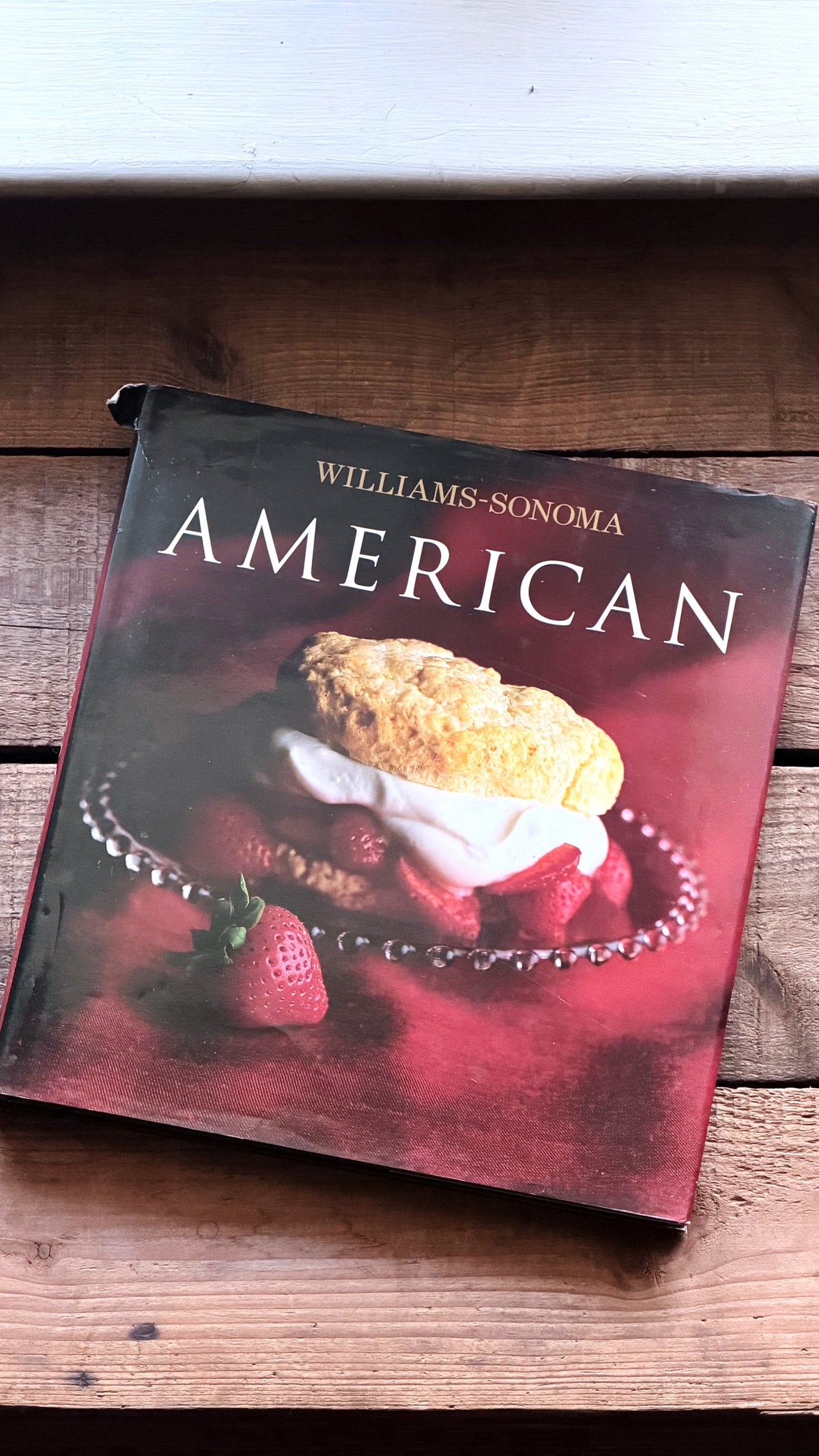 Williams-Sonoma American cookbook resting on a rustic wooden surface.