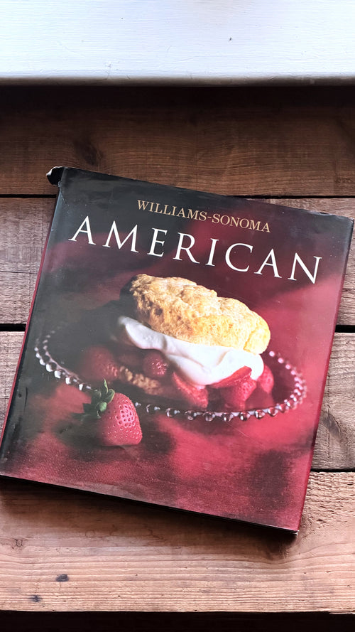 Williams-Sonoma American cookbook resting on a rustic wooden surface.