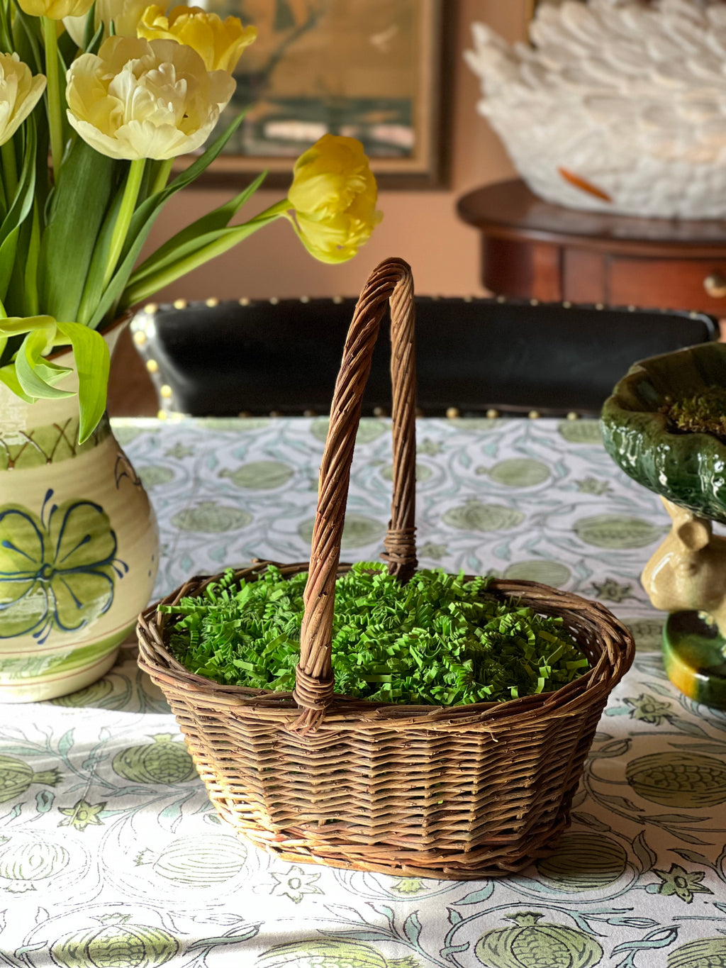 vintage woven willow basket with handle on neutral surface