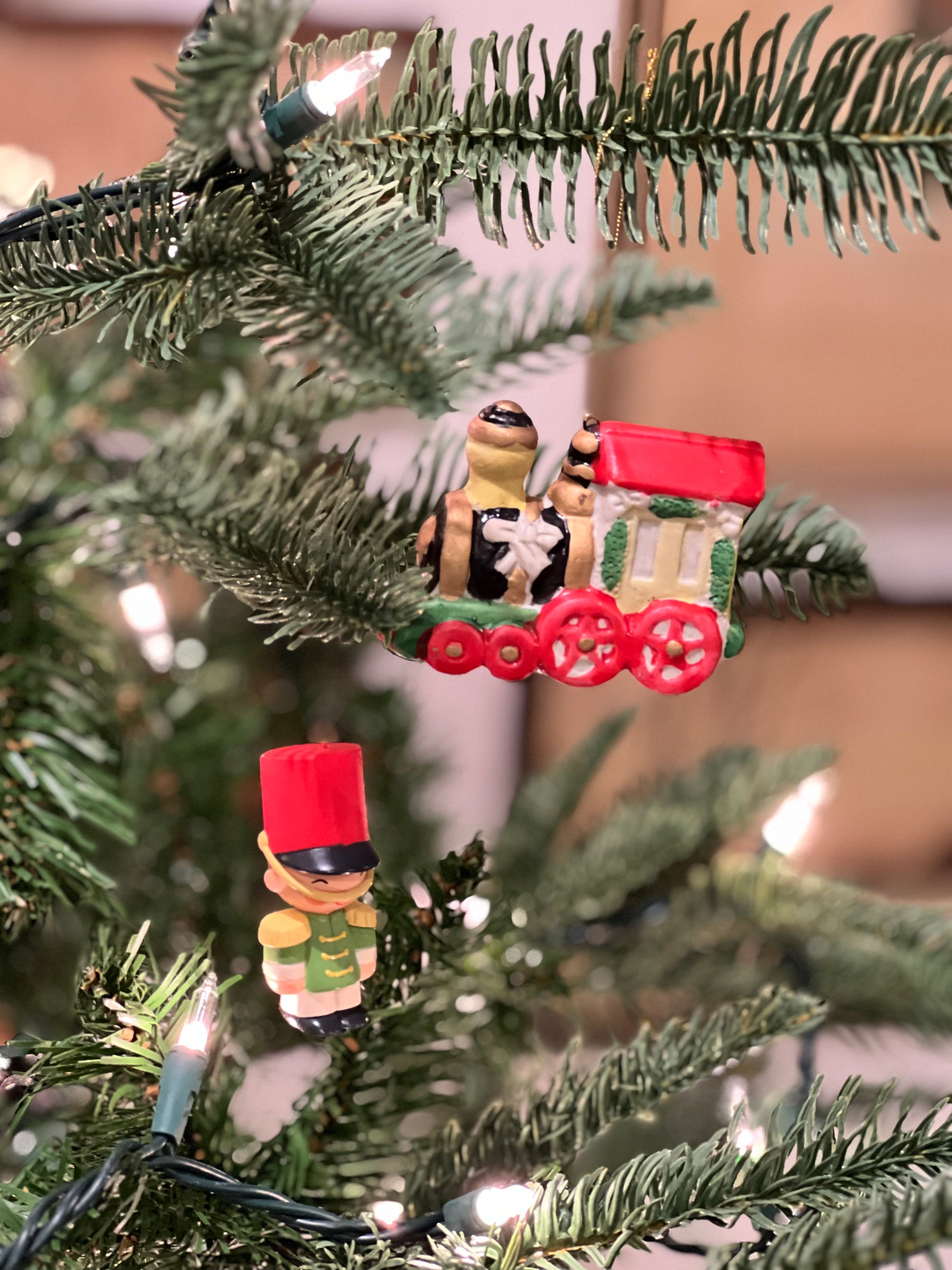 Christmas tree ornament with two figures and a red wagon on a decorated tree.