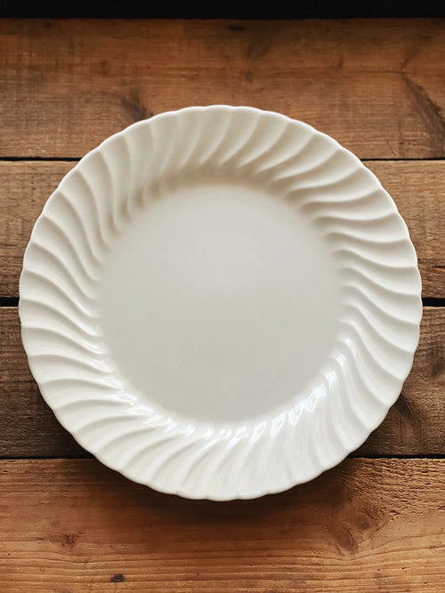 Vintage Johnson Brothers Regency dinner plate photographed overhead on a warm wood tabl