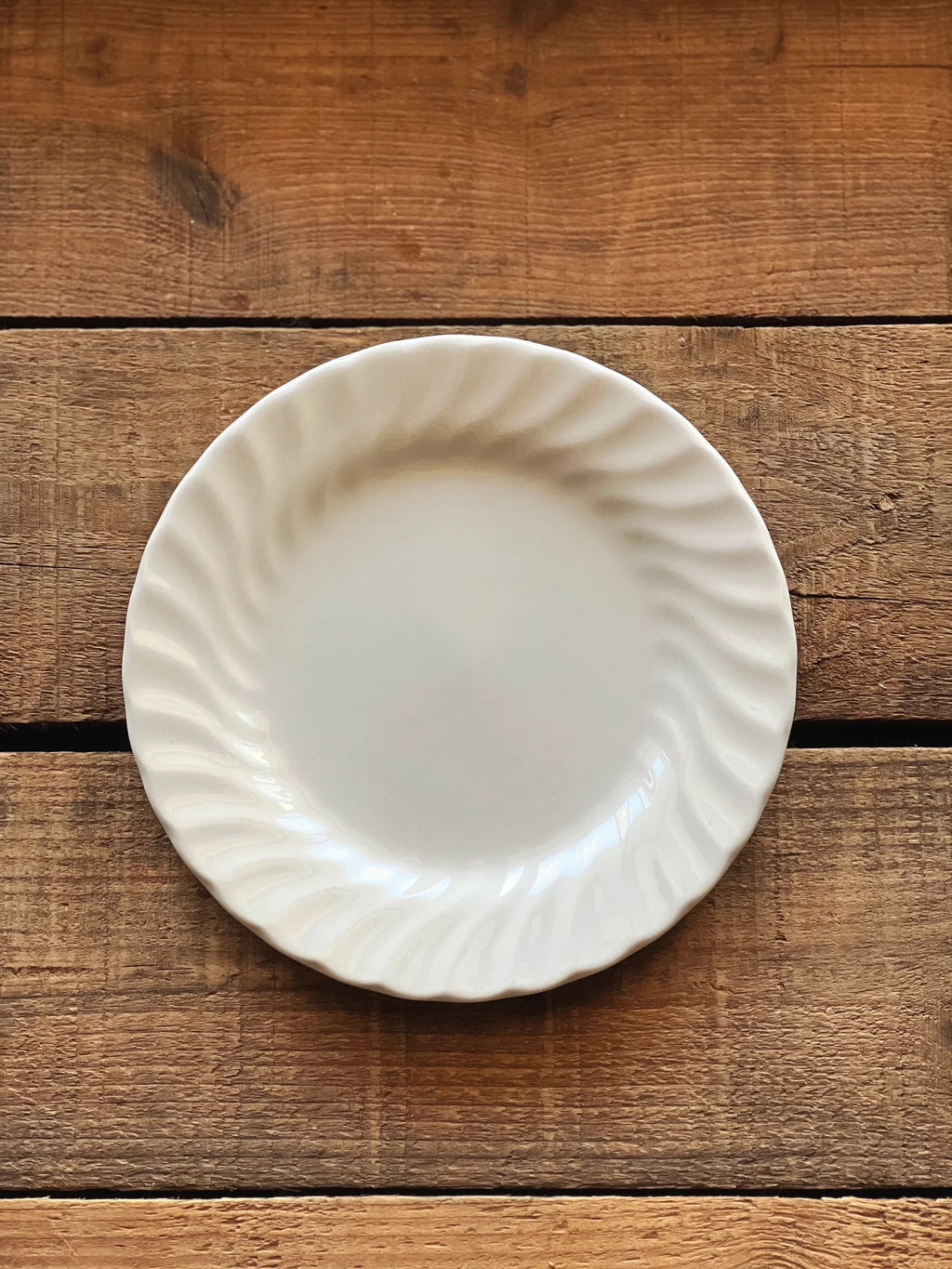 Vintage Johnson Brothers Regency bread and butter plate photographed overhead on a warm wood table