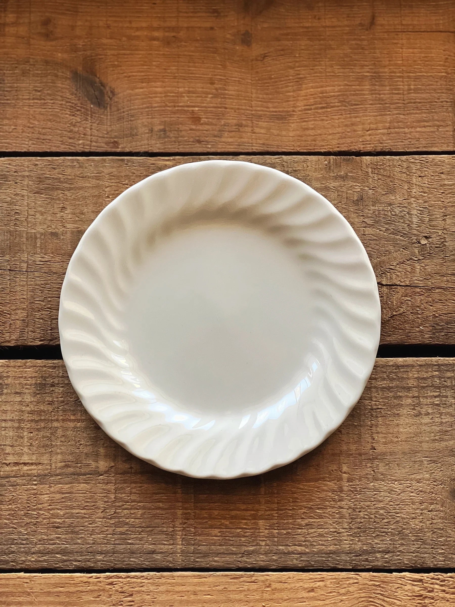 Vintage Johnson Brothers Regency bread and butter plate photographed overhead on a warm wood table