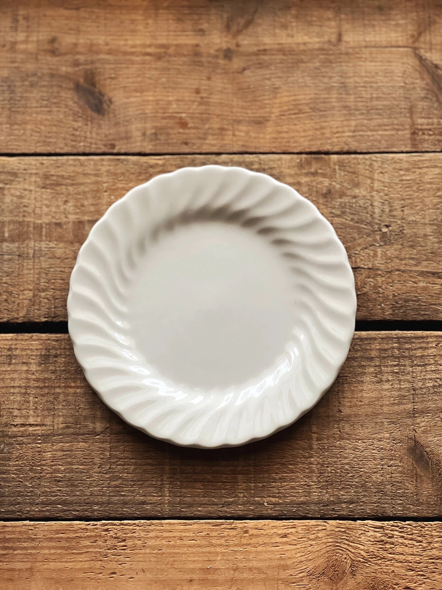 Vintage white ironstone bread and butter plate with embossed swirl design