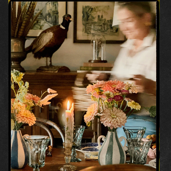Dining room with a table set for dinner, candles, and decorative elements.