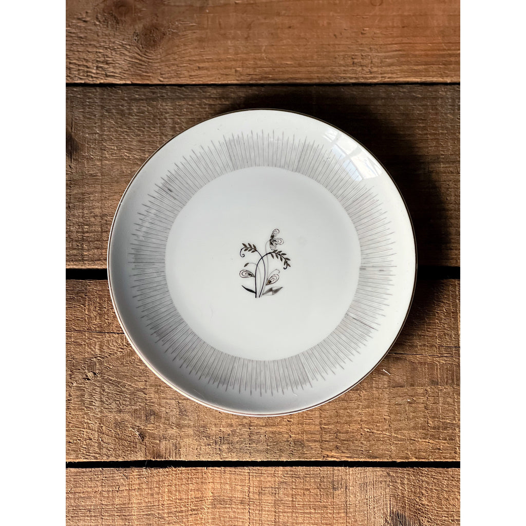 White plate with decorative edge and central design on a wooden surface