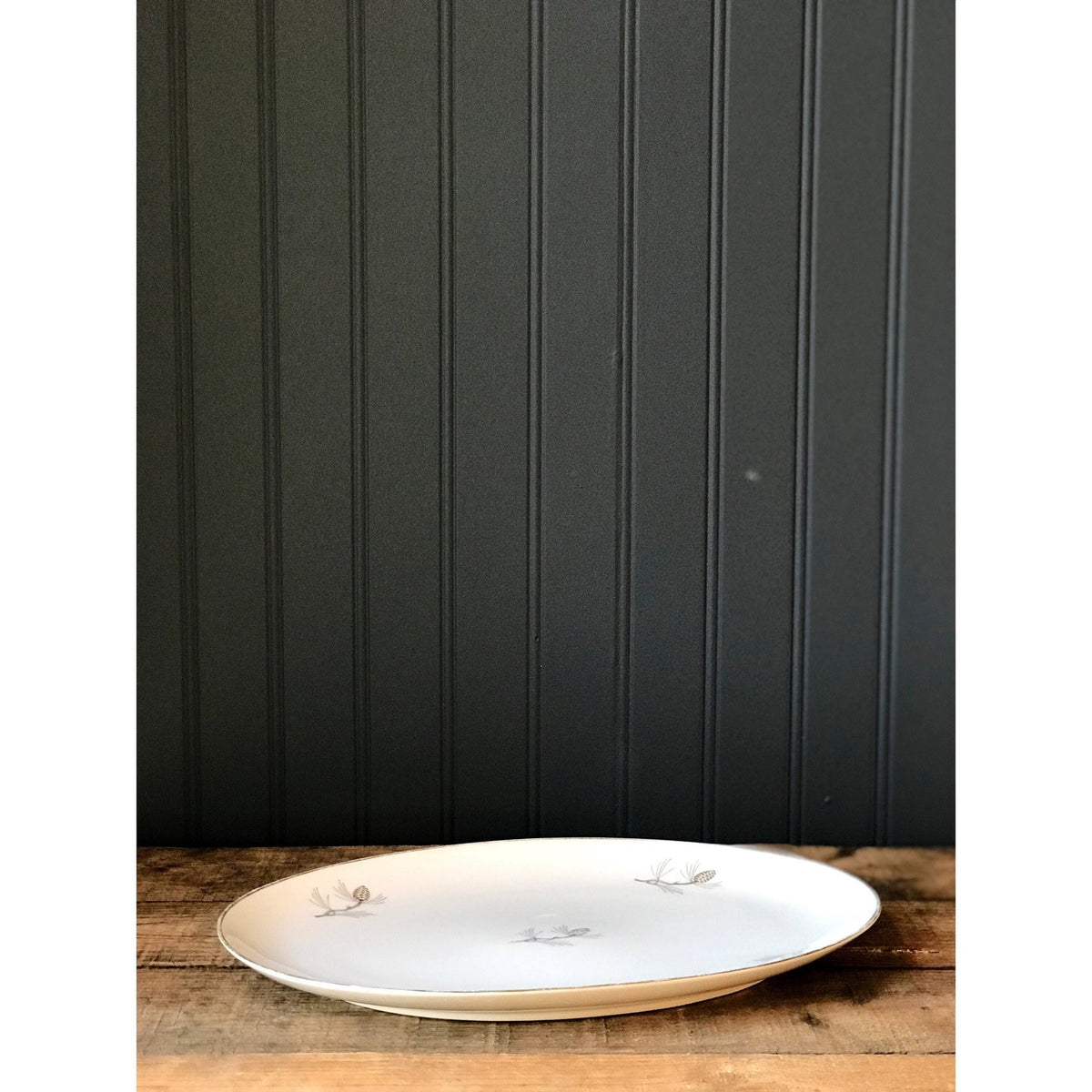 Vintage Sone China Japan Pinecone Oval Serving Platter on a wooden surface with a dark paneled wall background
