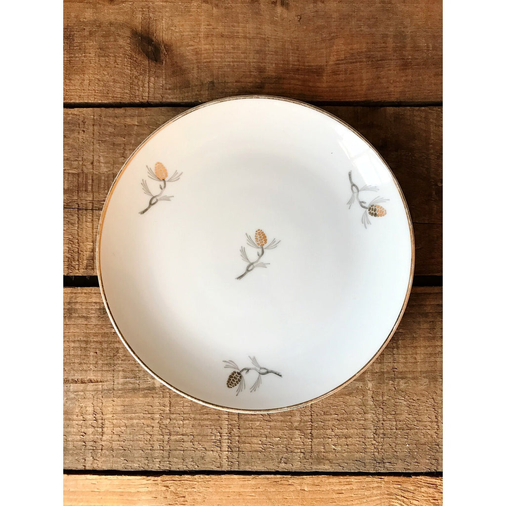 Decorative plate with pinecone patterns on a wooden surface
